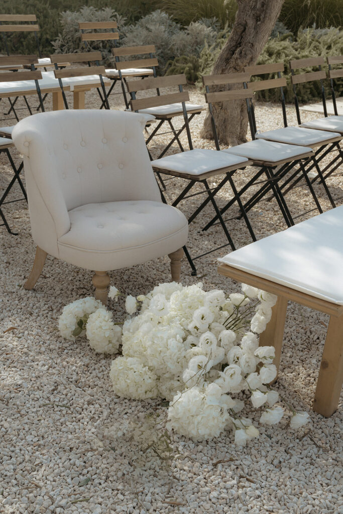Outdoor wedding ceremony setup with white florals and chairs at Masseria Moroseta in Puglia Italy