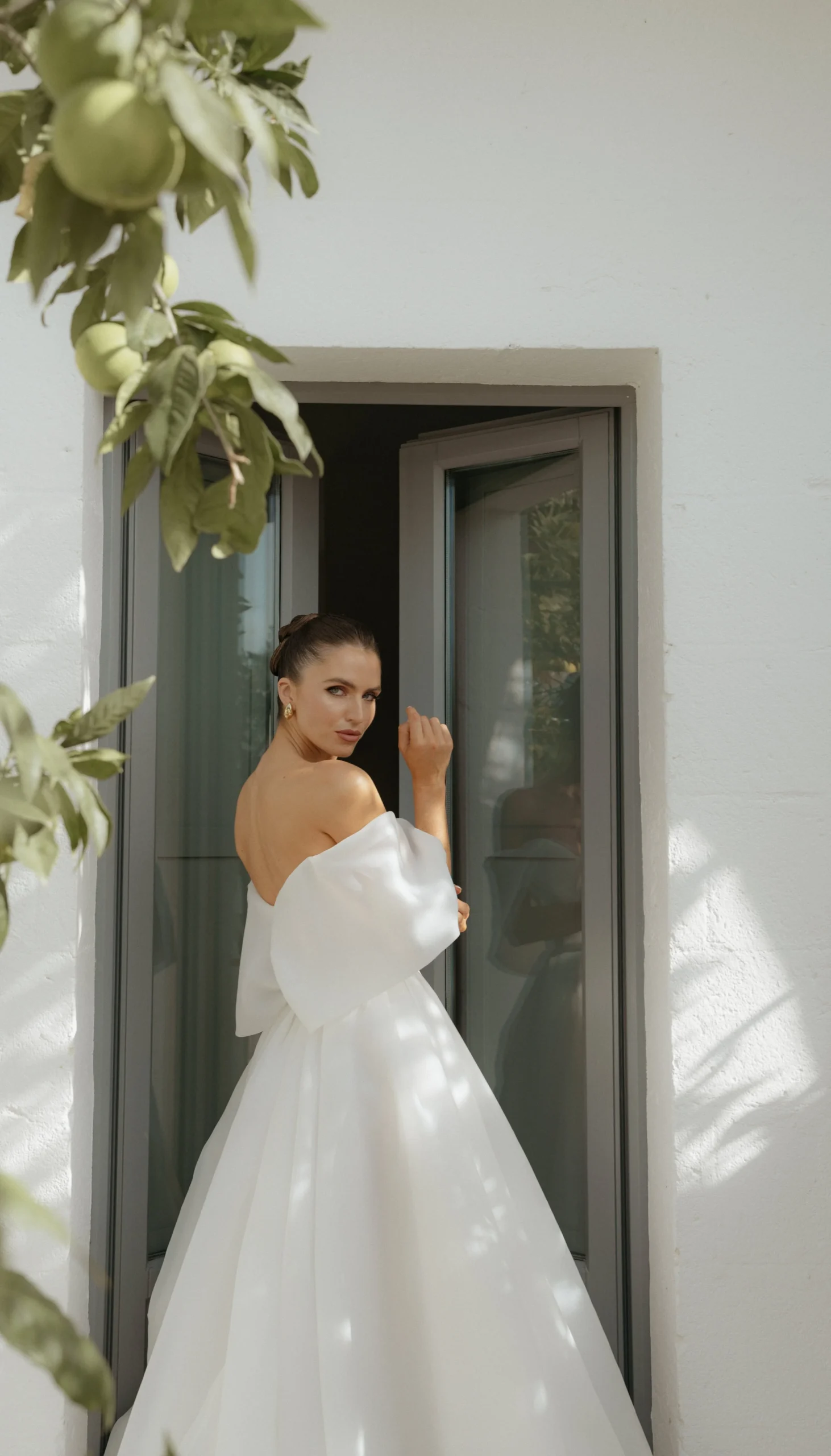 Radiant and beaming with joy, the beautiful bride graces the doorway of her room after getting ready. Her smile, as bright as the sun, captures the anticipation and excitement of the day ahead. With every detail perfected, she is ready to step into her fairytale moment and embrace the journey of a lifetime