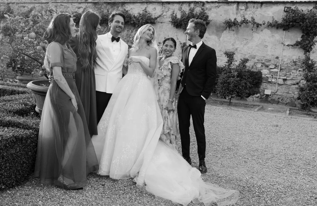 Why Luxury Wedding Photography Is About Trust, Not Shot Lists Bride and groom standing with close friends in a relaxed, candid moment during a wedding day