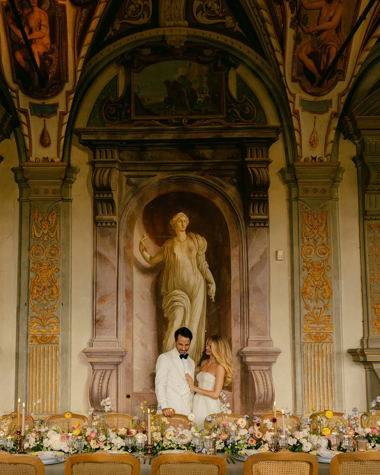 bride and groom portrait session photo admiring their beautifully designed tablescape styled by Kaleb Norman James