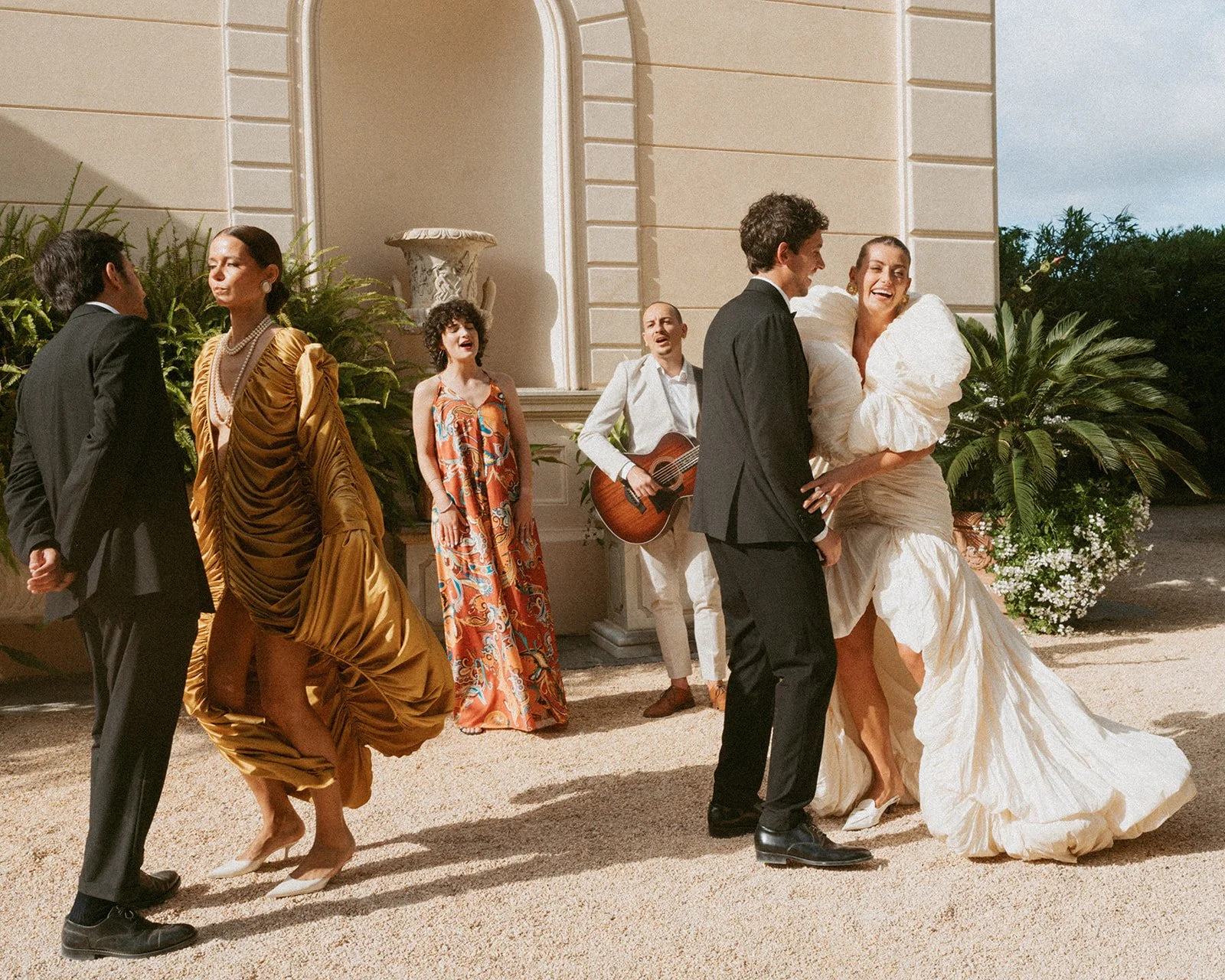  The bride, groom, and guests dancing together with live music from Jamin the Jukebox—vocals and guitar filling the air. Everyone’s caught up in the energy, moving freely and smiling, creating a joyful, unforgettable moment that feels warm and alive. 