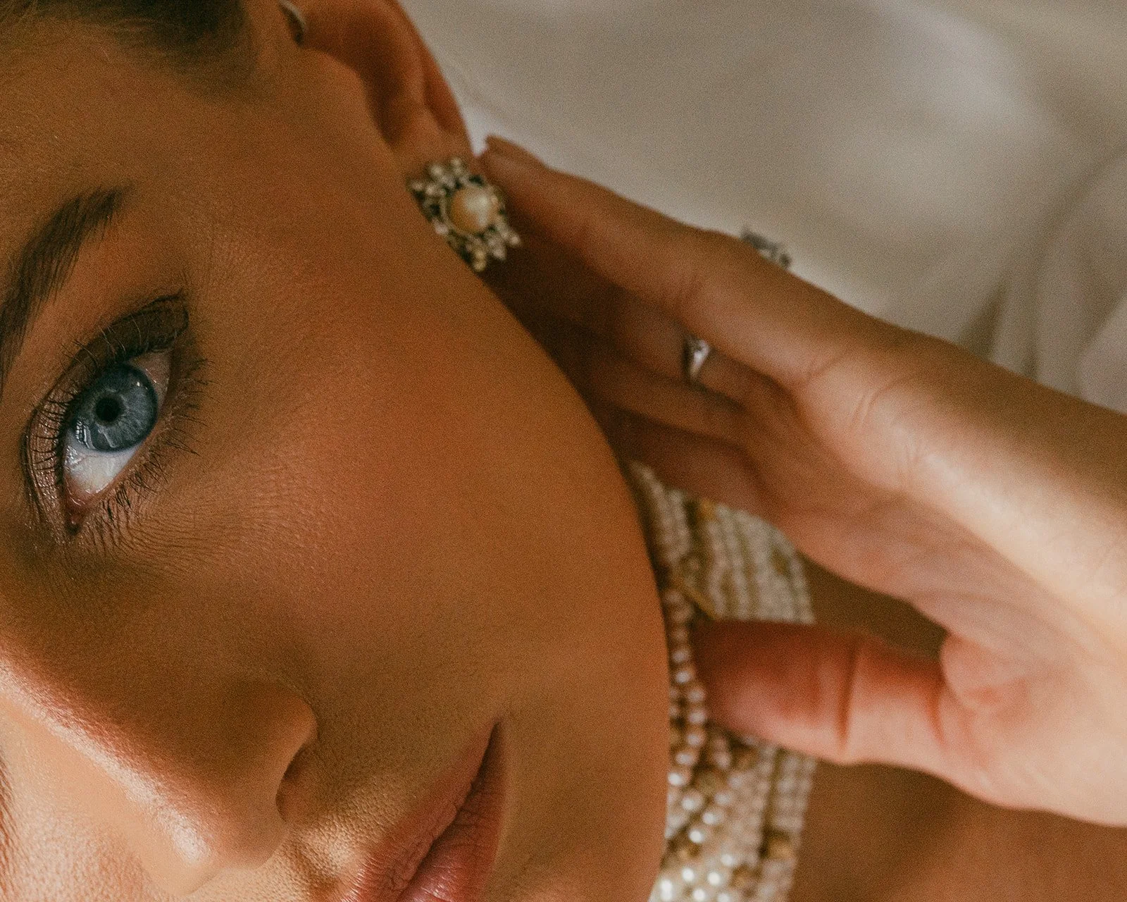  The kind of beauty you can’t manufacture — the soft trace of a fingertip, the quiet luxury of pearls, the way her gaze holds both excitement and calm. A moment suspended between getting ready and stepping into the story of her day.   