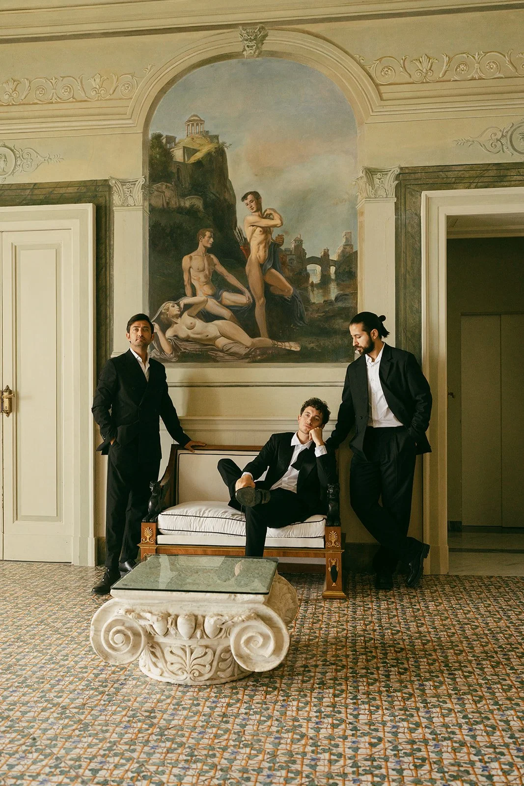  Inside Villa Astor’s frescoed salon, three groomsmen pause between moments — each carrying their own quiet charisma. The centuries-old mural behind them tells its own love story, and in the stillness, you can almost hear the echo of history. This is where timeless architecture meets modern elegance — a setting that makes every frame feel like part of a bigger, more meaningful narrative 