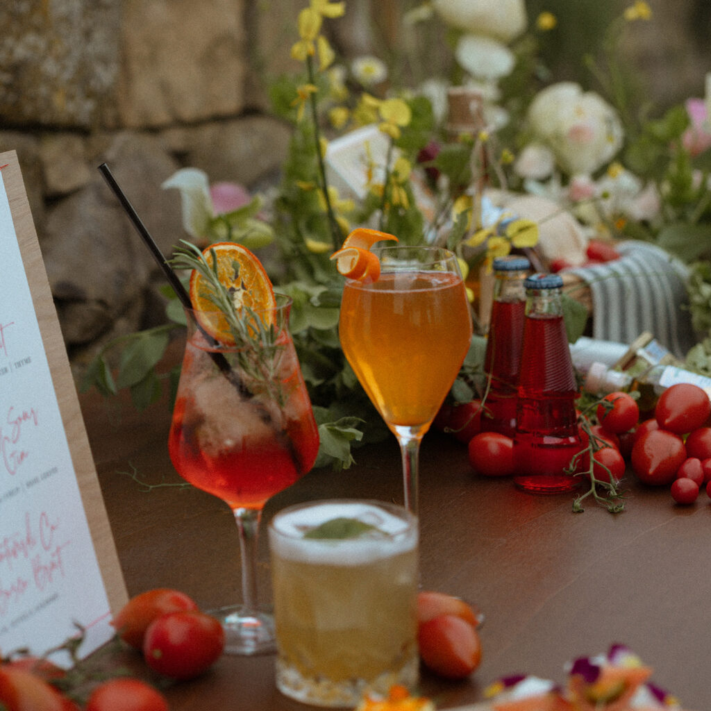 Colorful Italian cocktails styled with fresh citrus, tomatoes, and floral accents at Monteverdi Tuscany welcome dinner.