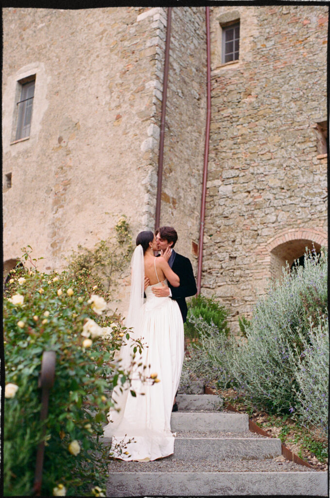 A Timeless Monteverdi Tuscany Wedding Bride and groom embracing on garden steps at Monteverdi Tuscany