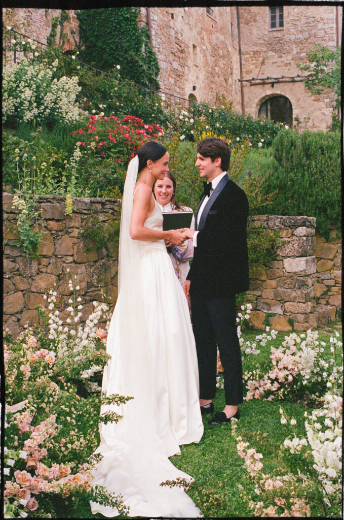 A Timeless Monteverdi Tuscany Wedding Wedding ceremony at Monteverdi Tuscany with couple exchanging vows in garden setting
