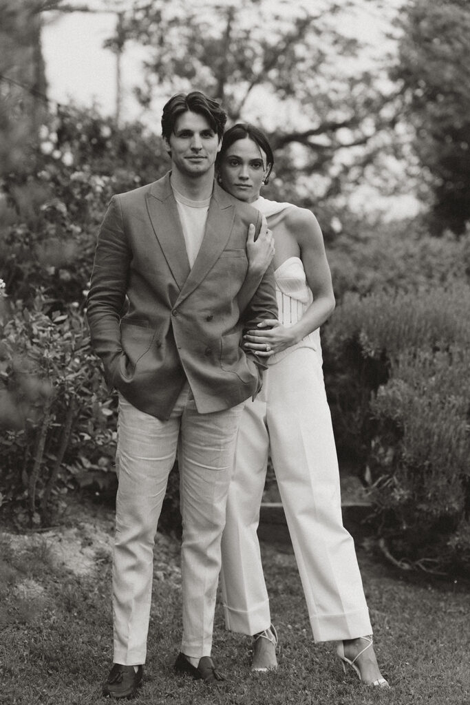 Bride in Danielle Frankel corset and groom in tailored linen suit stand together during welcome dinner at Monteverdi Tuscany.