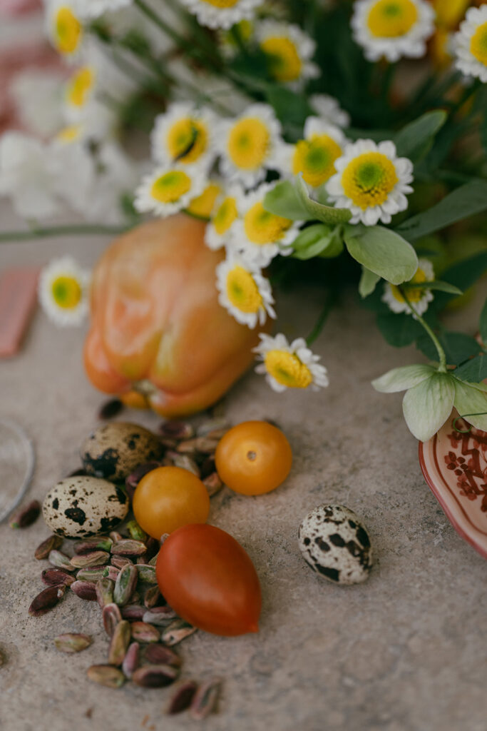 Close-up of Monteverdi Tuscany wedding table design with pink floral plates, grapes, and pastel florals arranged among candles.