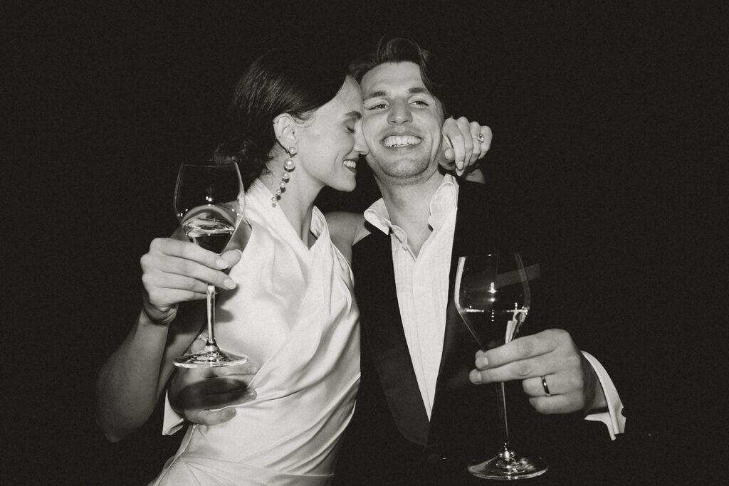 Bride and groom toast and laugh during their wedding reception at Monteverdi Tuscany.