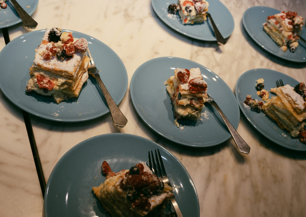 Slices of millefoglie wedding cake with berries served on blue plates at Monteverdi Tuscany.