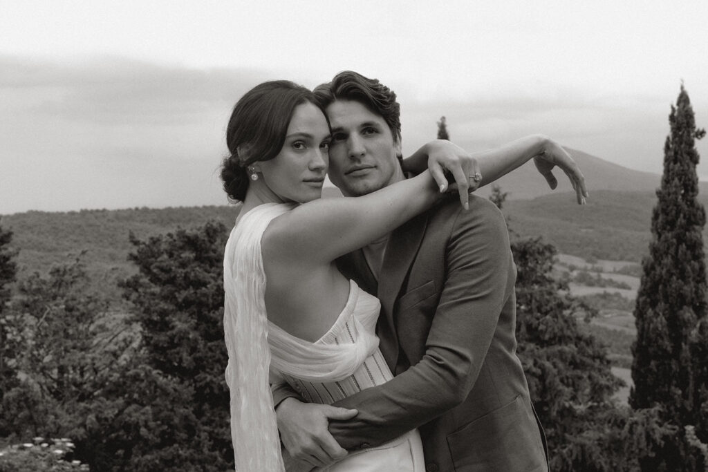 Bride and groom embrace in Monteverdi Tuscany, framed by the hills of Val d’Orcia during an intimate Italian wedding.