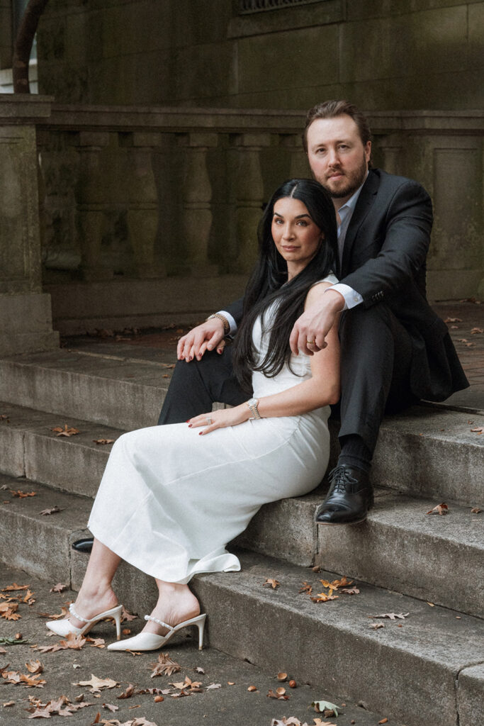 Couple sitting close together on stone steps during their Charlotte editorial couples session.